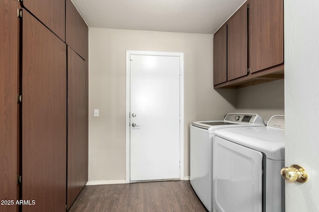 washroom featuring cabinets, washing machine and dryer, and hardwood / wood-style flooring