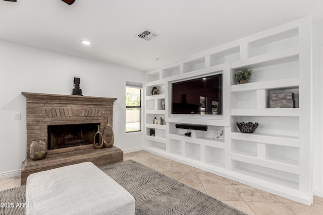 living area featuring visible vents, tile patterned flooring, built in features, a fireplace, and baseboards
