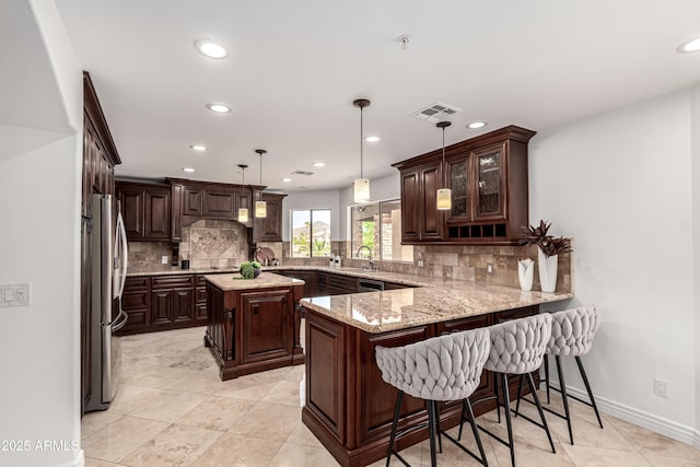 kitchen featuring visible vents, a peninsula, dark brown cabinetry, recessed lighting, and stainless steel appliances