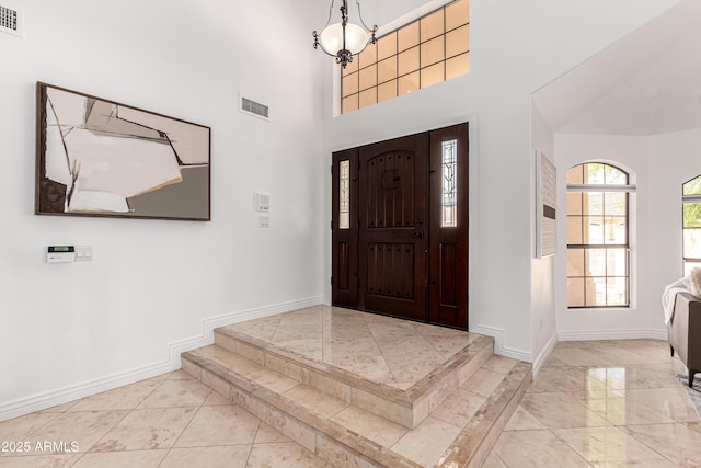entryway with baseboards, visible vents, and marble finish floor