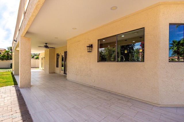 view of patio with fence and a ceiling fan