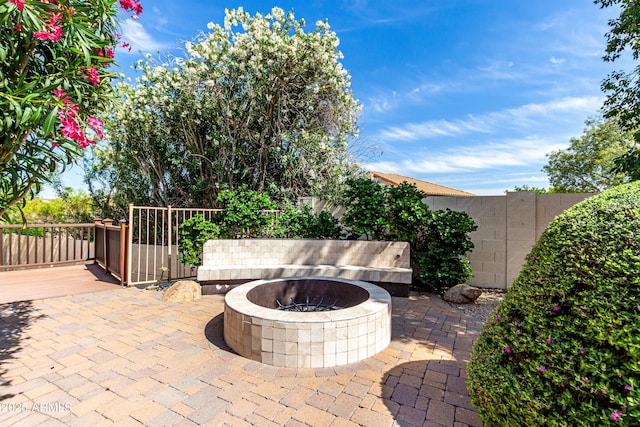 view of patio / terrace with fence, an outdoor fire pit, and a deck