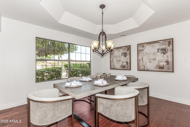 dining room featuring baseboards, visible vents, a tray ceiling, and a chandelier