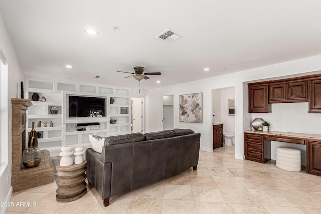 living room featuring a ceiling fan, visible vents, built in shelves, and recessed lighting