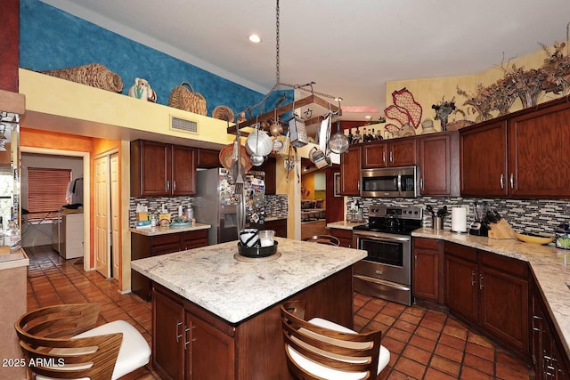 14605 S 35th Pl, Phoenix, AZ 85044 - kitchen with stainless steel appliances, backsplash, independent washer and dryer, a center island, and recessed lighting