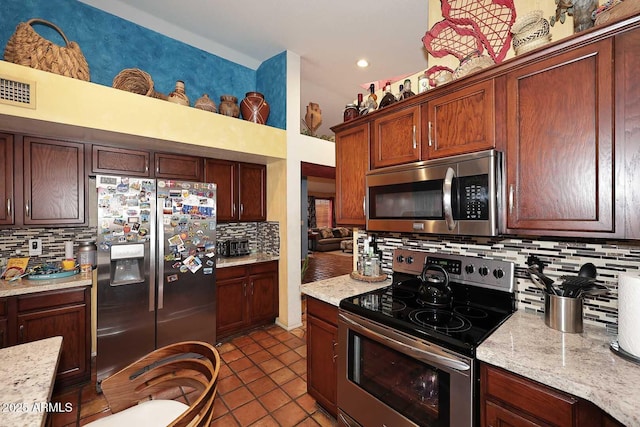 14605 S 35th Pl, Phoenix, AZ 85044 - kitchen with appliances with stainless steel finishes, backsplash, dark tile patterned flooring, recessed lighting, and light stone countertops