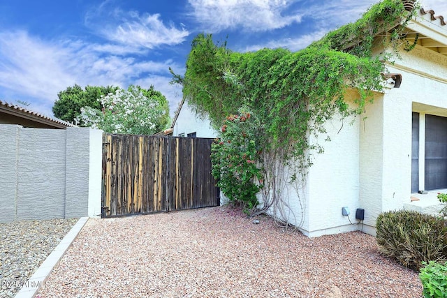 14605 S 35th Pl, Phoenix, AZ 85044 - view of side of home featuring stucco siding, fence, and a gate