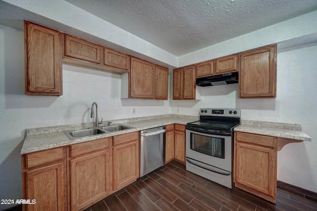 kitchen featuring stainless steel appliances, a textured ceiling, dark wood-type flooring, and sink