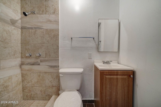 bathroom featuring vanity, toilet, and tiled shower