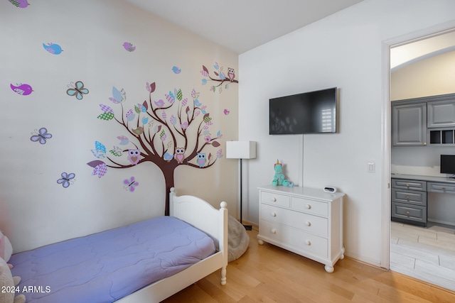 bedroom with light hardwood / wood-style floors and built in desk