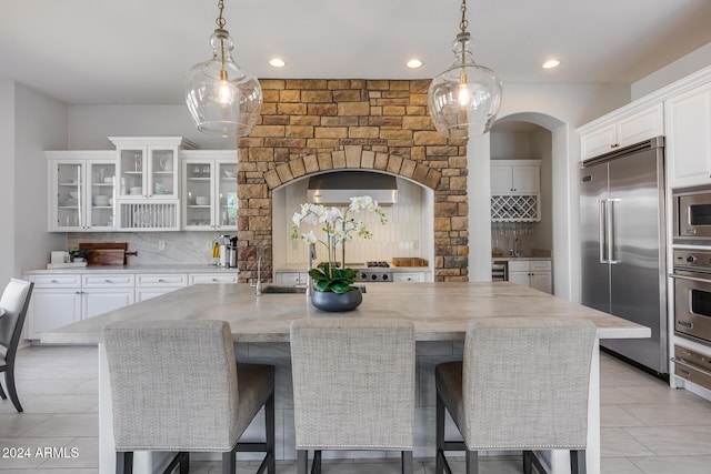 2340 W Horsetail Trl, Phoenix, AZ 85085 - kitchen with built in appliances, arched walkways, decorative backsplash, white cabinetry, and recessed lighting