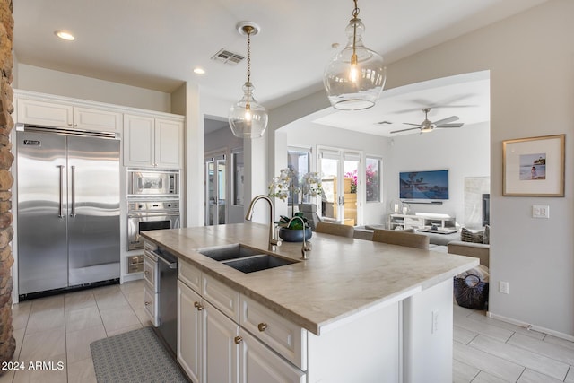 2340 W Horsetail Trl, Phoenix, AZ 85085 - kitchen featuring built in appliances, a sink, open floor plan, white cabinets, and a kitchen island with sink