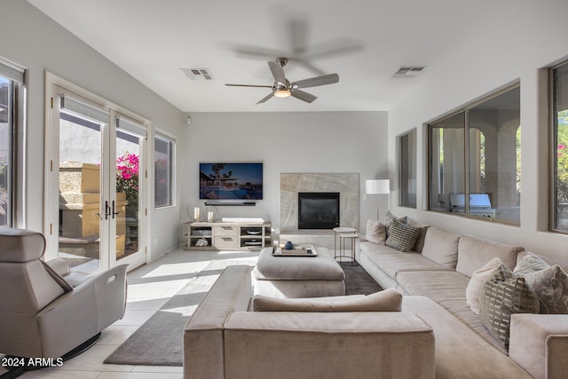 living room with ceiling fan, light tile patterned flooring, and a fireplace