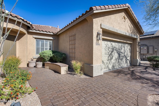 2340 W Horsetail Trl, Phoenix, AZ 85085 - view of side of property featuring stucco siding, an attached garage, a tiled roof, and decorative driveway