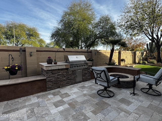 view of patio featuring area for grilling, an outdoor kitchen, and a fire pit