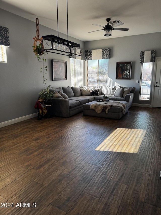 living room with ceiling fan and dark wood-type flooring