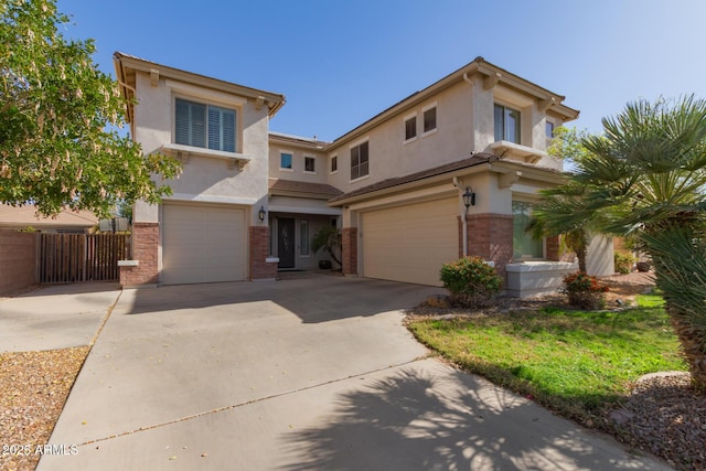 view of front of home with fence, driveway, stucco siding, a garage, and brick siding