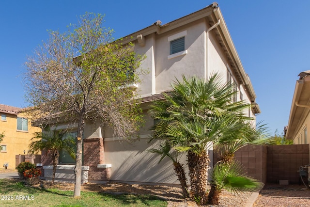 view of property exterior featuring stucco siding and fence