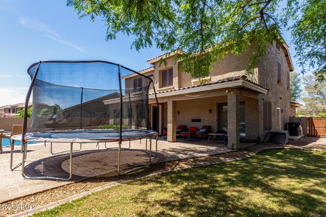 4123 S Wayne Pl, Chandler, AZ 85249 - back of house featuring a trampoline, a patio area, and stucco siding