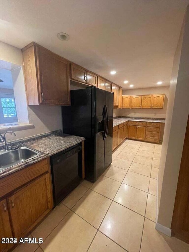 kitchen featuring light tile patterned floors, brown cabinetry, black appliances, a sink, and recessed lighting