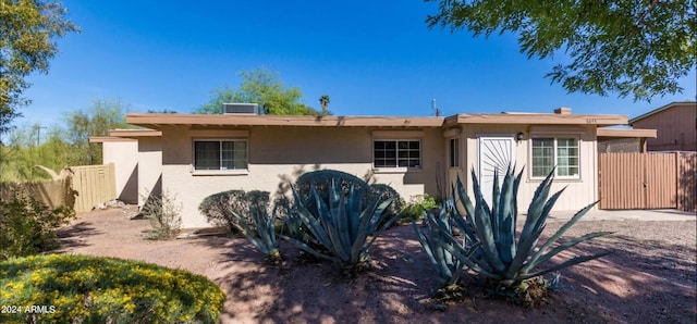 single story home featuring central AC, fence, and stucco siding