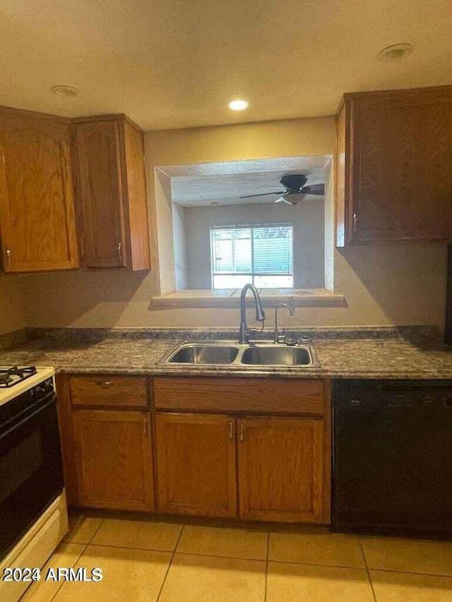 kitchen featuring light tile patterned floors, brown cabinetry, dishwasher, gas range oven, and a sink