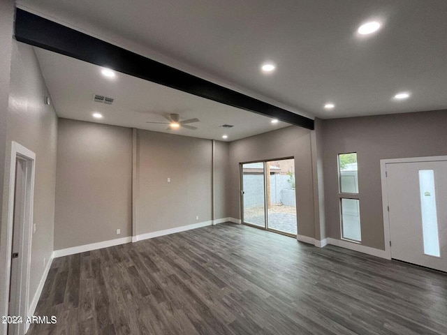 unfurnished room featuring baseboards, visible vents, beam ceiling, and wood finished floors