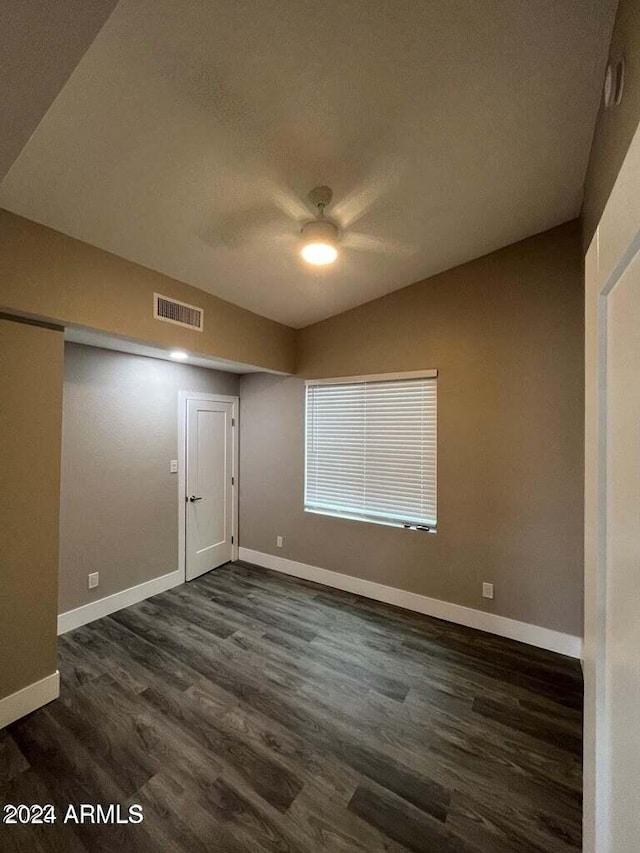 spare room featuring baseboards, visible vents, a ceiling fan, dark wood-style floors, and a textured ceiling