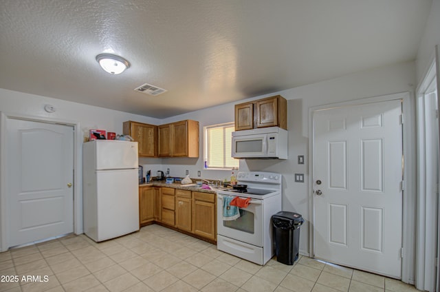 kitchen featuring sink, a textured ceiling, and white appliances