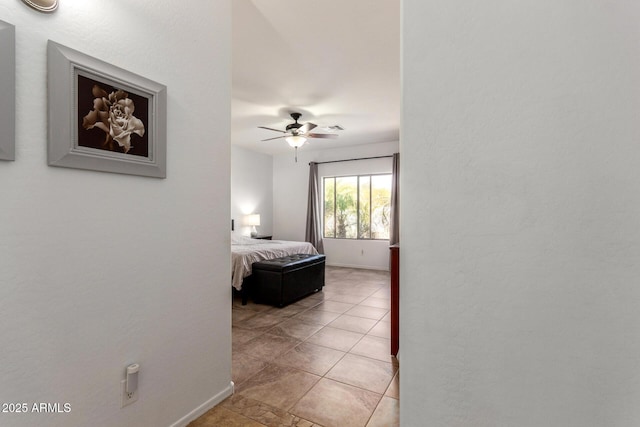 bedroom with visible vents, ceiling fan, baseboards, and light tile patterned floors