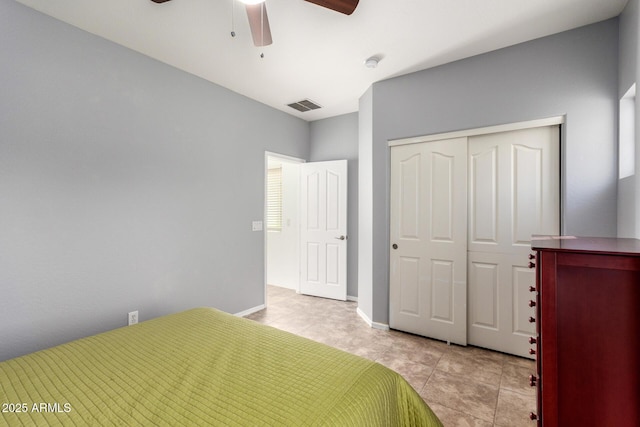 unfurnished bedroom featuring ceiling fan, light tile patterned flooring, visible vents, baseboards, and a closet