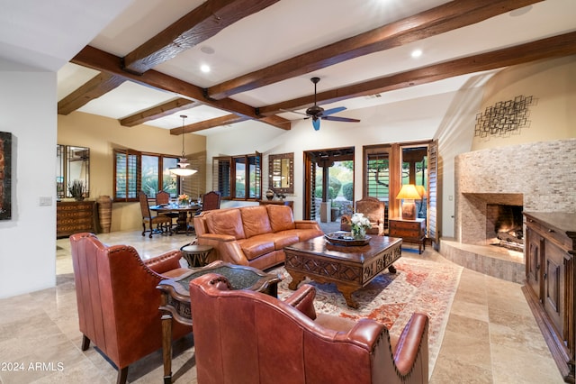 living room with ceiling fan, beam ceiling, and a fireplace