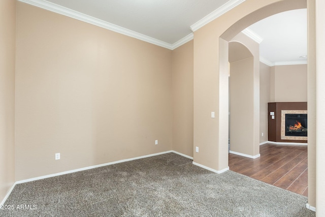 4253 N Yates Ave, Prescott Valley, AZ 86314 - carpeted spare room featuring ornamental molding, arched walkways, baseboards, and a glass covered fireplace