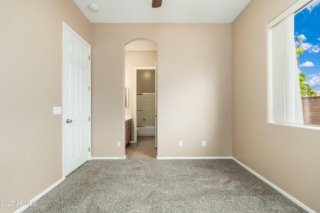 4253 N Yates Ave, Prescott Valley, AZ 86314 - unfurnished bedroom featuring light carpet, arched walkways, baseboards, and connected bathroom