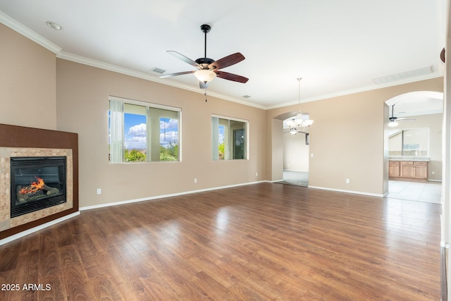 4253 N Yates Ave, Prescott Valley, AZ 86314 - unfurnished living room with ceiling fan, ornamental molding, a glass covered fireplace, wood finished floors, and arched walkways