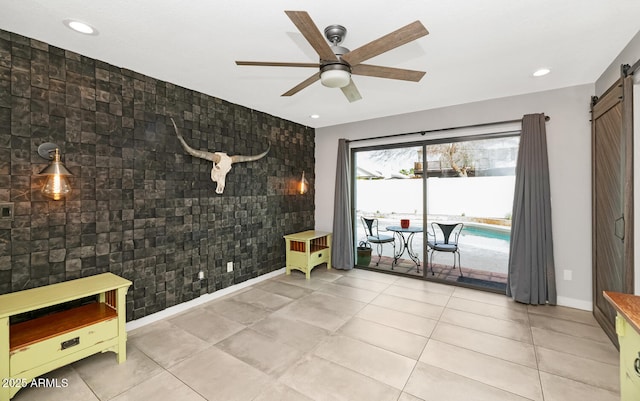 unfurnished room featuring a ceiling fan, recessed lighting, a barn door, baseboards, and an accent wall