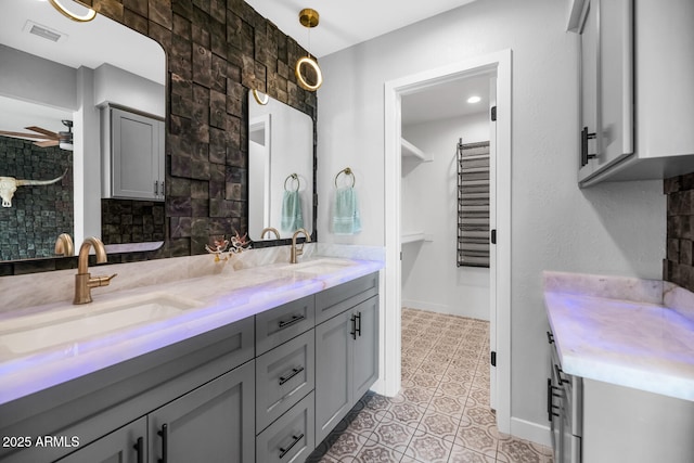 bathroom featuring tasteful backsplash, a ceiling fan, visible vents, and a sink