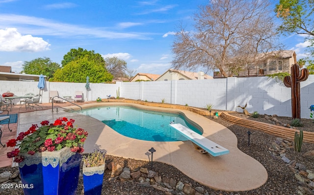 view of swimming pool with a patio, a diving board, a fenced backyard, and a fenced in pool