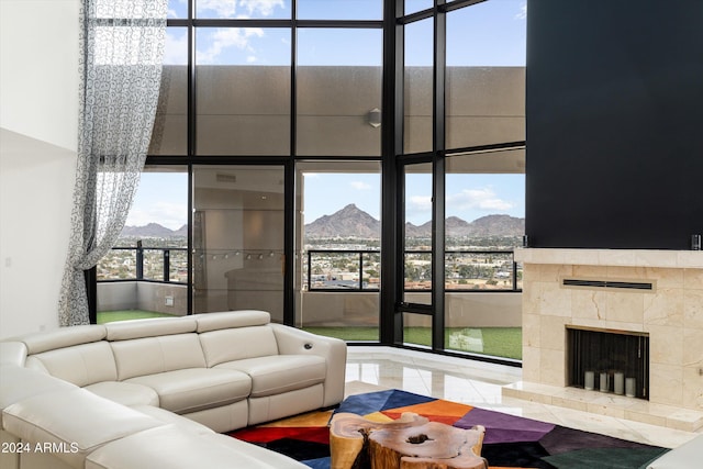 living room with tile patterned floors, a tiled fireplace, and a mountain view