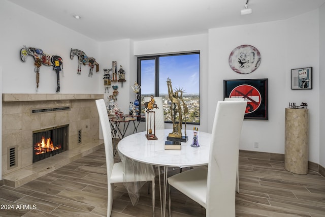 dining area featuring a tile fireplace and hardwood / wood-style floors