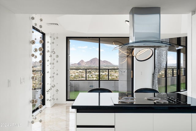 kitchen with a mountain view, black electric stovetop, and white cabinetry