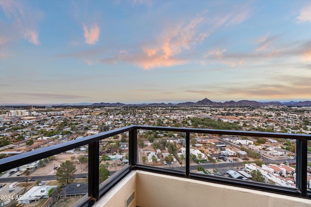 balcony at dusk featuring a mountain view