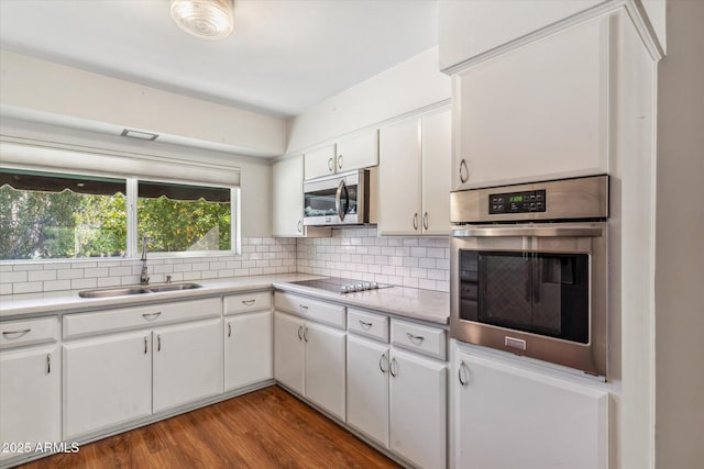 kitchen featuring appliances with stainless steel finishes, sink, decorative backsplash, and white cabinets