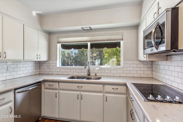 kitchen featuring tasteful backsplash, stainless steel appliances, sink, and white cabinets