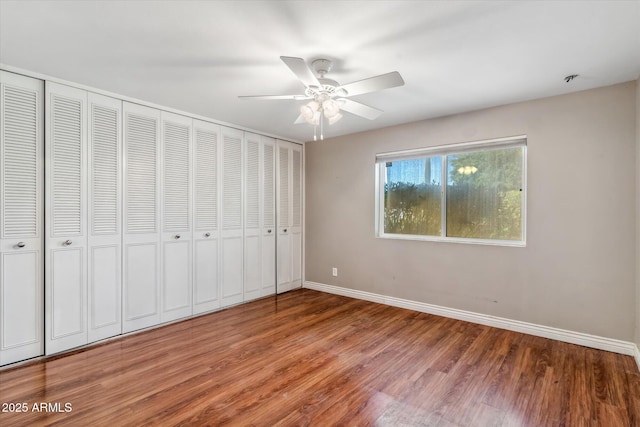 unfurnished bedroom featuring hardwood / wood-style floors, a closet, and ceiling fan