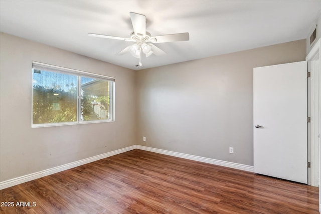 spare room with dark wood-type flooring and ceiling fan