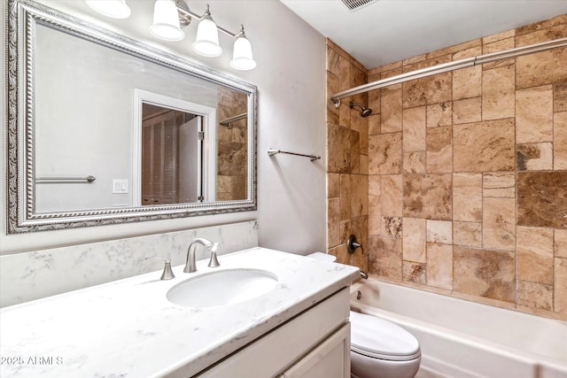 full bathroom featuring vanity, toilet, and tiled shower / bath