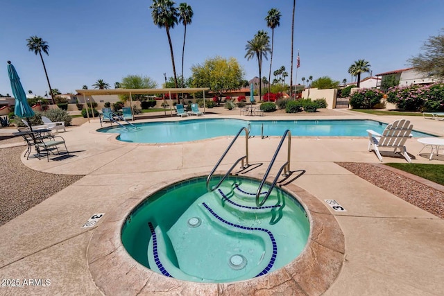 view of swimming pool featuring a community hot tub and a patio area