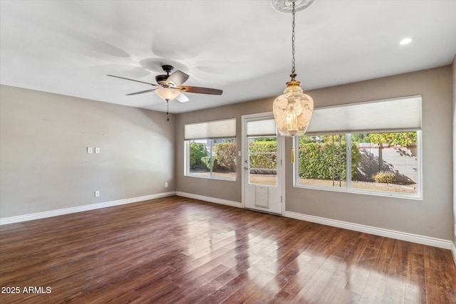 spare room featuring dark wood-type flooring and ceiling fan