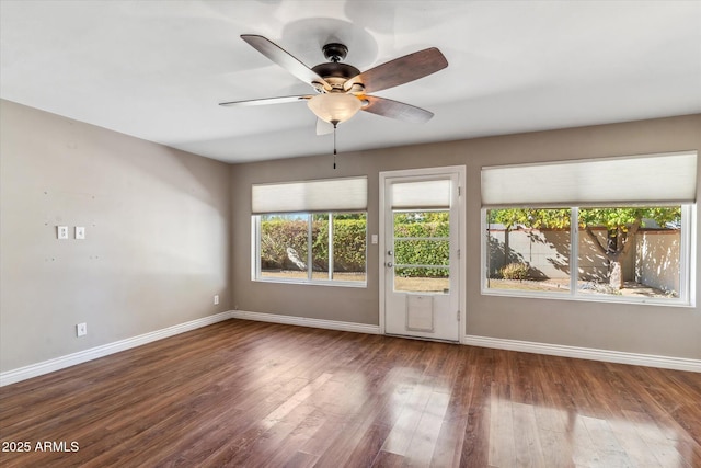 spare room with dark wood-type flooring and ceiling fan